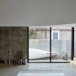 Arthur Residence 콘크리트 벽면과 유리창 너머 마당에 놓인 카누