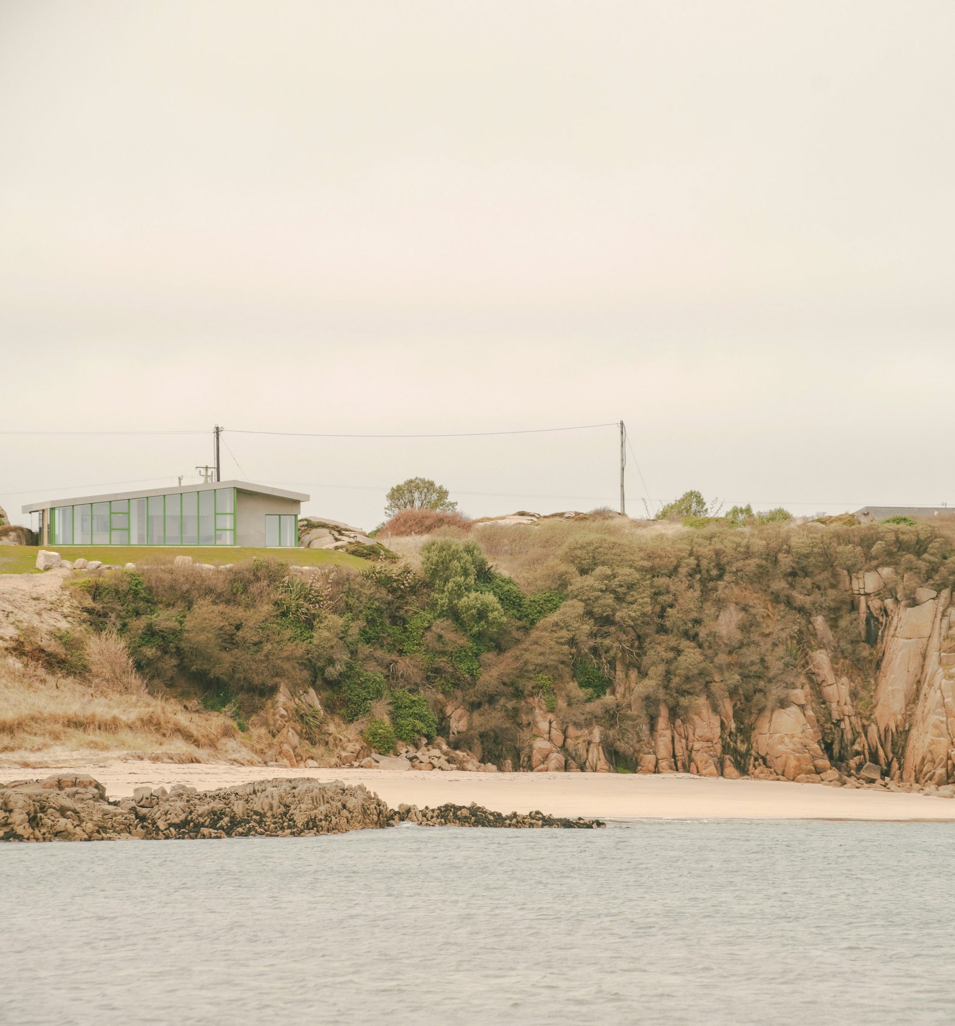 해변에서 올려다본 Cruit Island House, 화강암 절벽과 지붕선