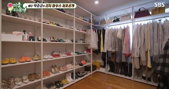 화이트 선반에 구두와 가방이 정리된 드레스룸 전경