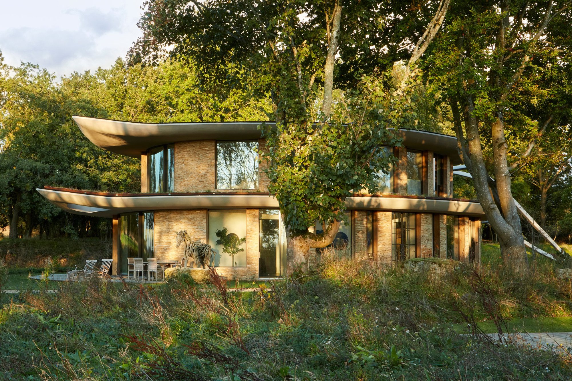 Leaf House 외관, 나무 사이로 보이는 곡선 지붕