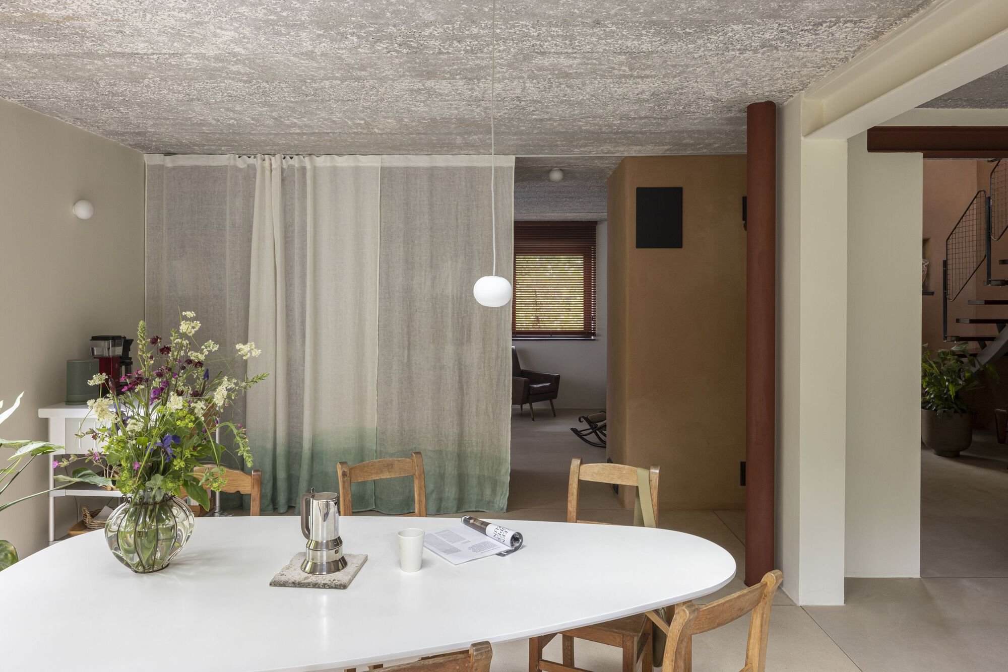 Omloop Farmhouse의 다이닝 공간, 목재 가구와 다짐 흙벽