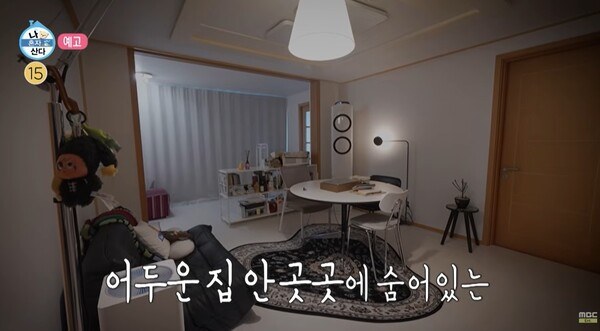 어둑한 거실을 넓게 잡은 화면과 문 옆에 걸린 소품들