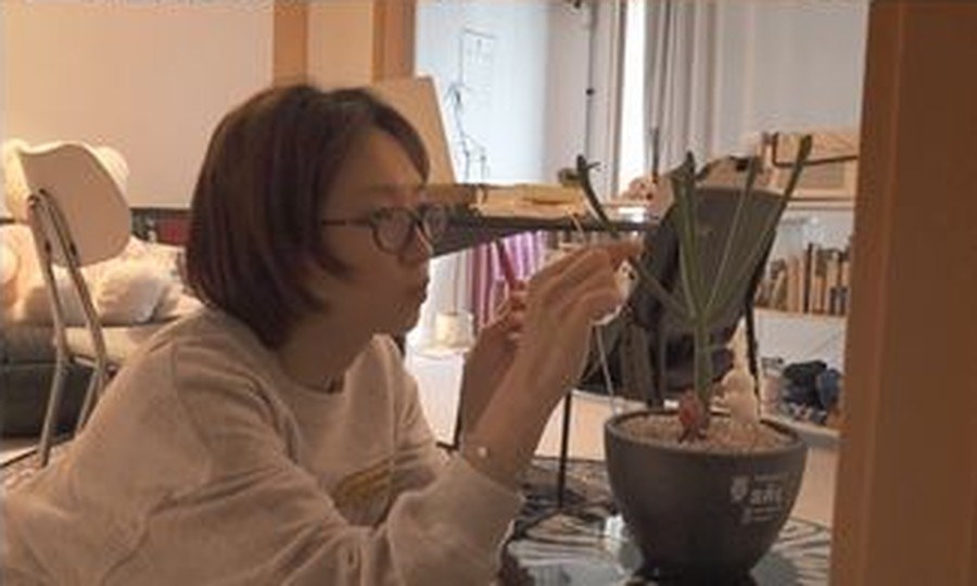 선반과 캔버스가 놓인 자리에서 화분을 손질하는 류혜영