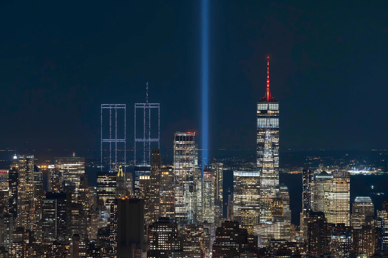 뉴욕 항구 위에 드론으로 재현된 9·11 Twin Towers 야경, 옆으로 One World Trade Center가 보인다