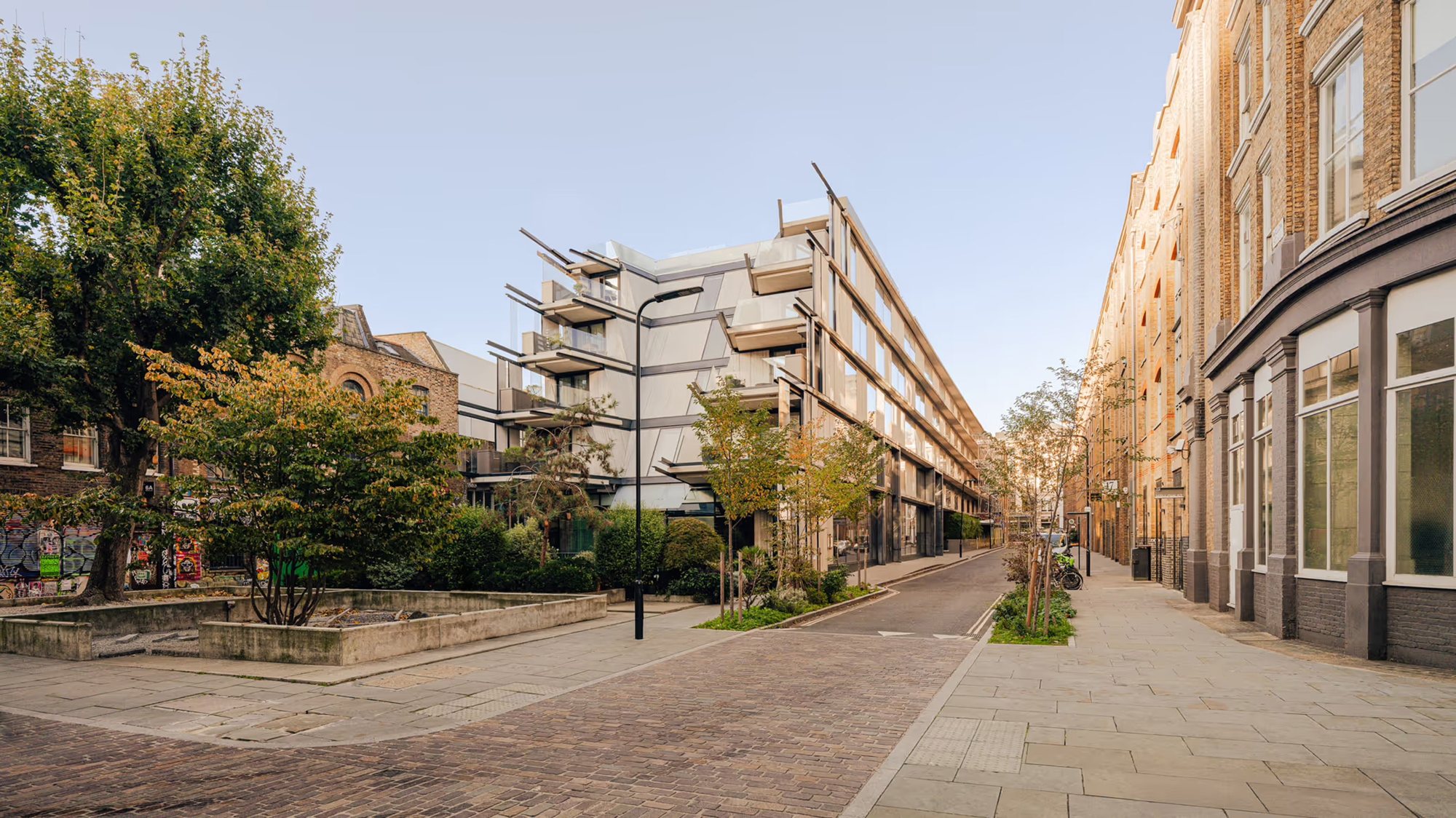 벽돌 창고 건물 사이 골목에서 본 Aethos Shoreditch 외관과 쇼디치 거리