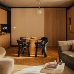 원목 수납장과 원형 식탁을 둔 Aethos Shoreditch 스위트 다이닝 공간