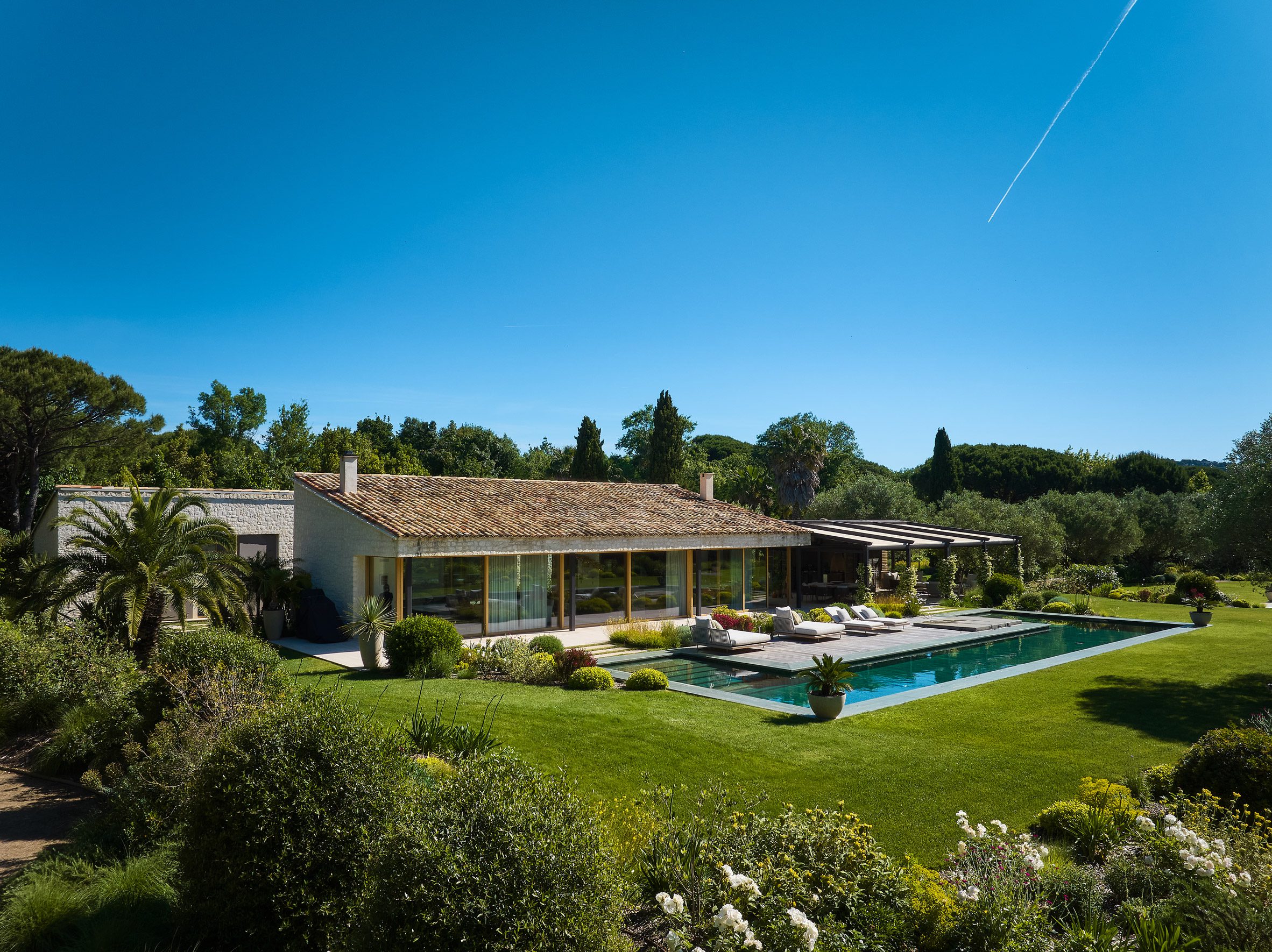 Carminati 전동 목재 창호 Skyline Drive를 한 면 전체에 두른 생트로페 인근 Villa Ramatuelle 외관과 수영장