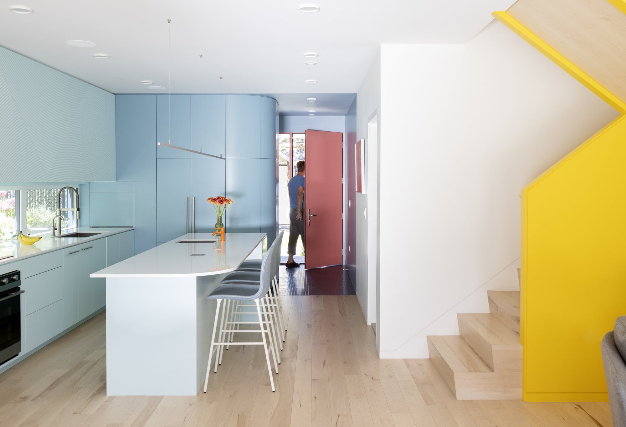 길게 이어진 창 백스플래시와 아일랜드가 있는 Fluevog House 주방