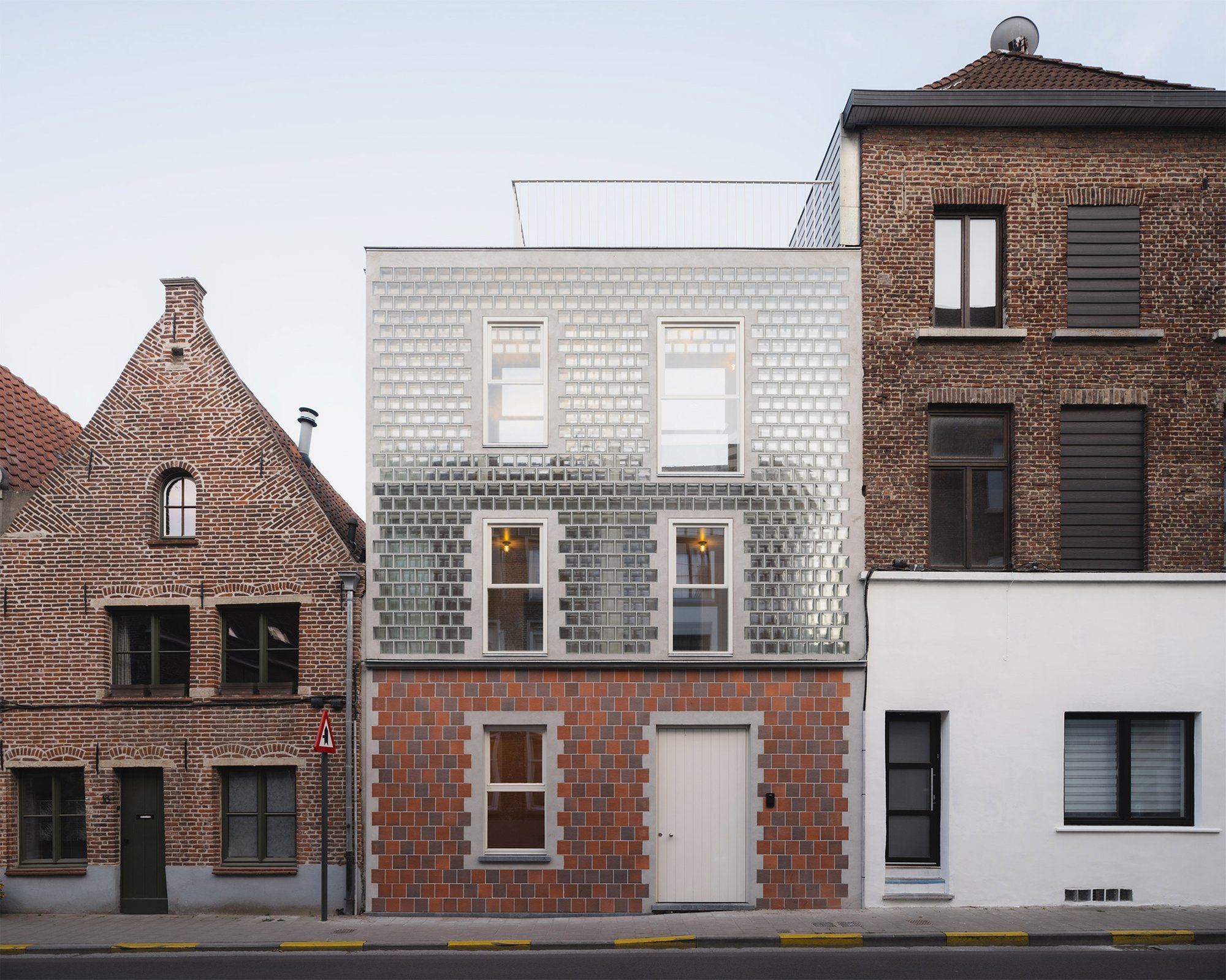 해질녘 유리벽돌 파사드에 불이 켜진 Glass Brick House