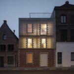저녁 무렵 불 켜진 Glass Brick House 파사드