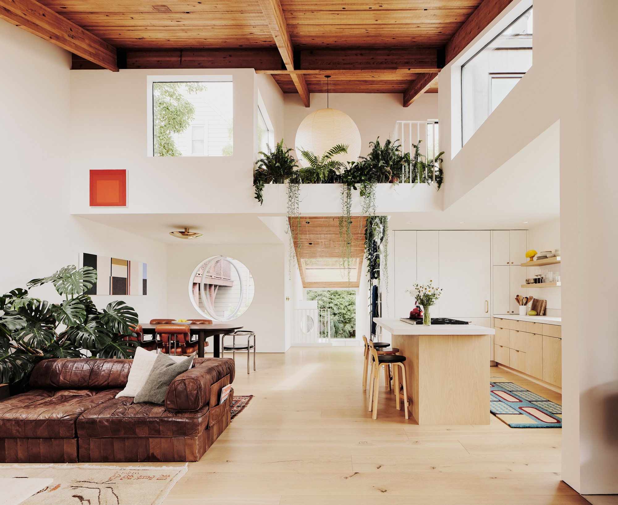 서까래를 노출한 목조 천장 아래 개방형 리모델링 거실과 주방, Hosono House