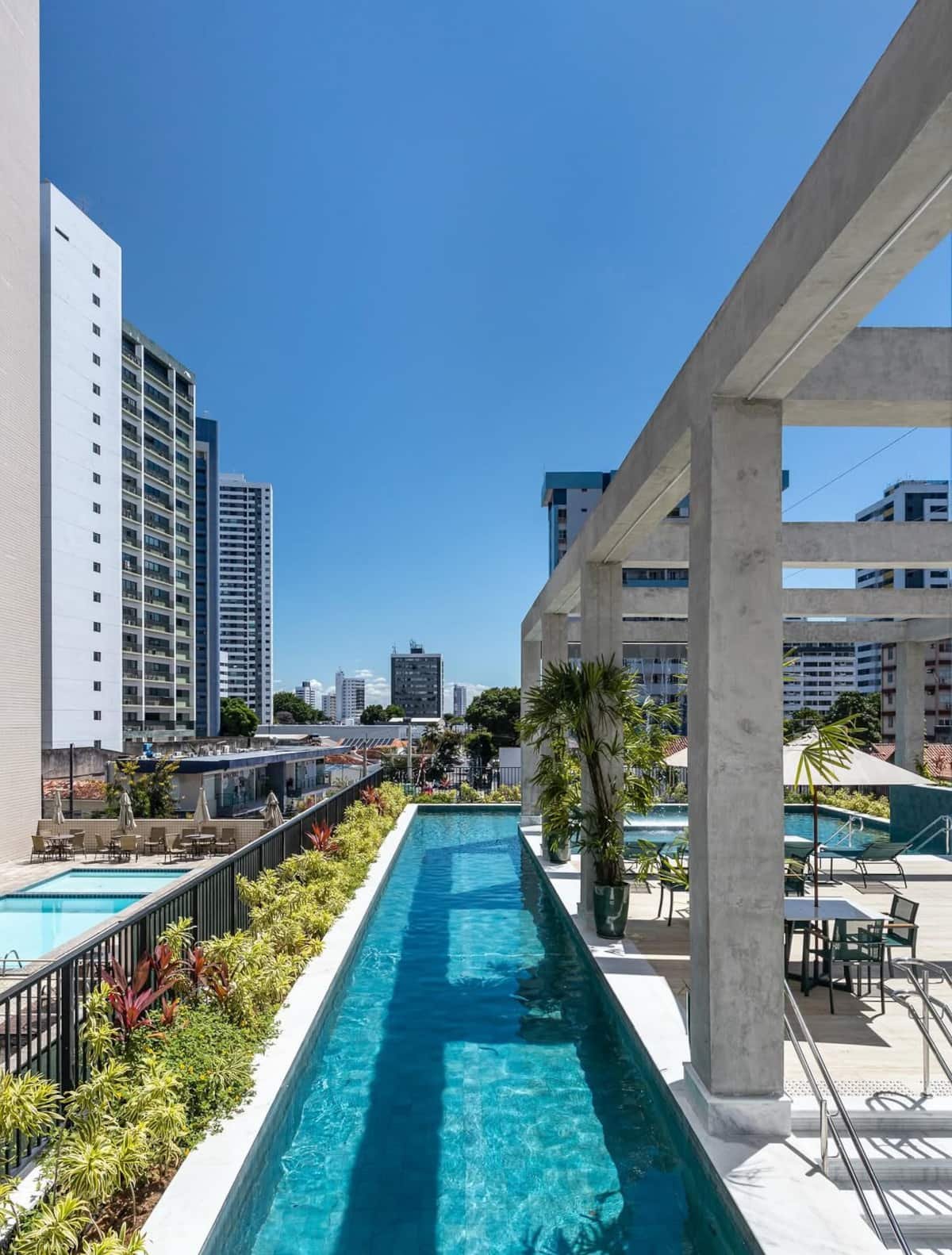 노출 콘크리트 페르골라 아래 놓인 Riverside Tolive 옥상 랩풀