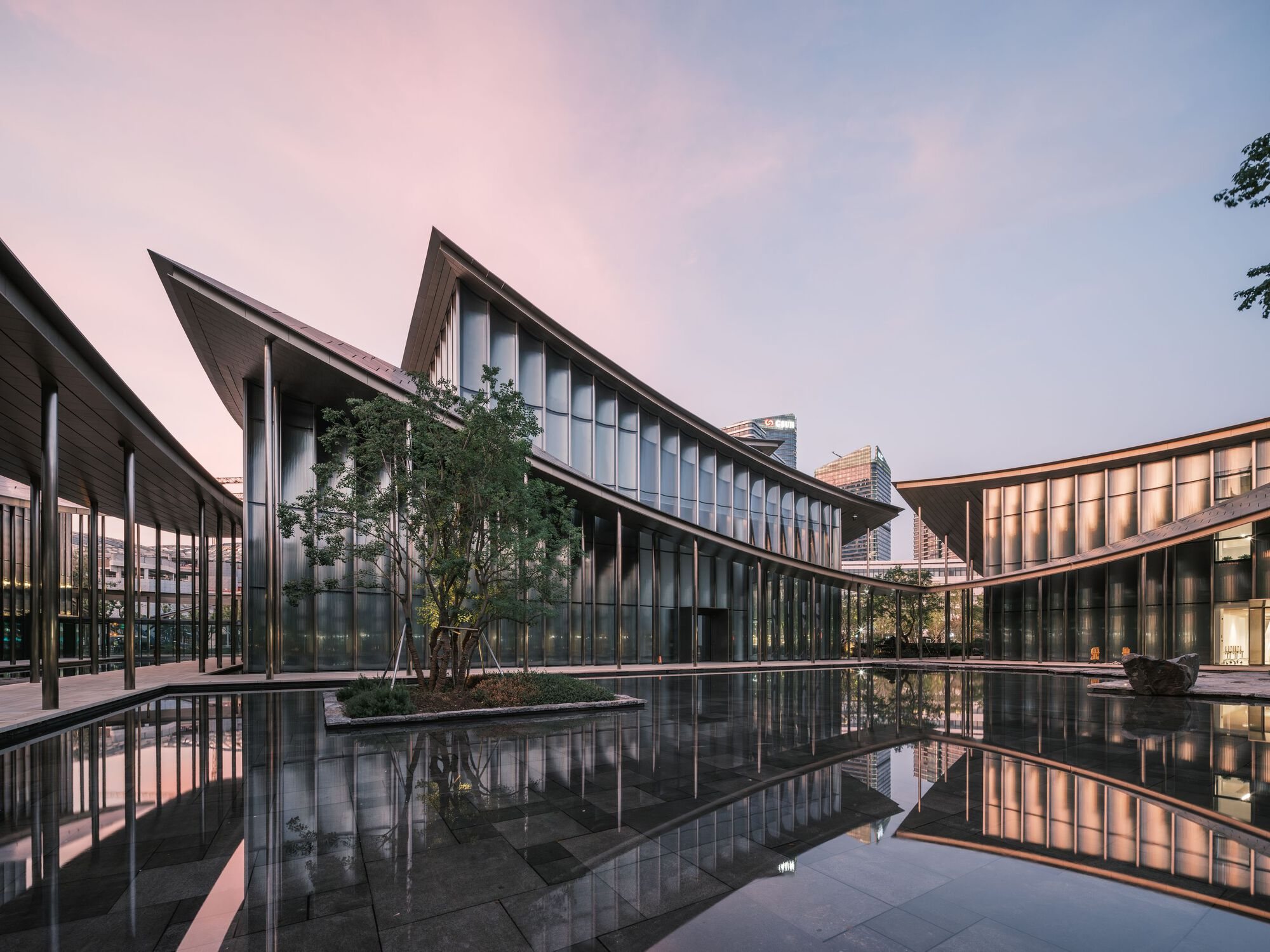 해 질 녘 수공간 정원을 둘러싼 Suzhou MoCA 파빌리온들