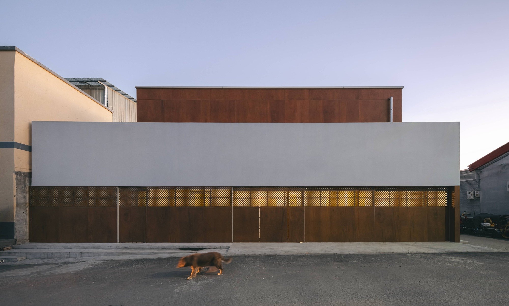 마을 길에서 본 A House in Xueshan Village 정면, 코퍼 톤 목재 패널 차고문과 화이트 벽