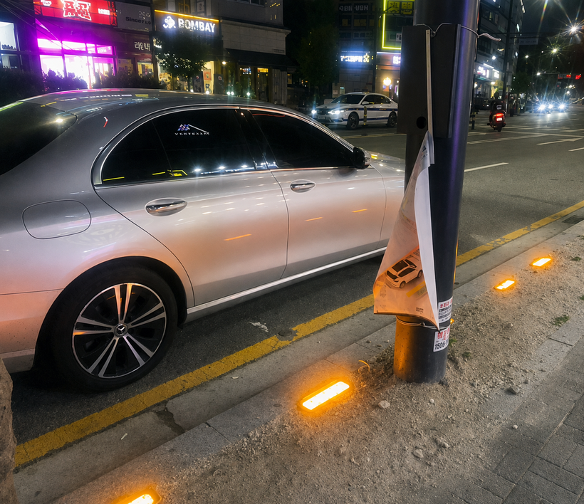 연석 옆 바닥에 켜진 주황색 LED 유도등과 주정차한 승용차, 불법주정차 AI 관리시스템 현장