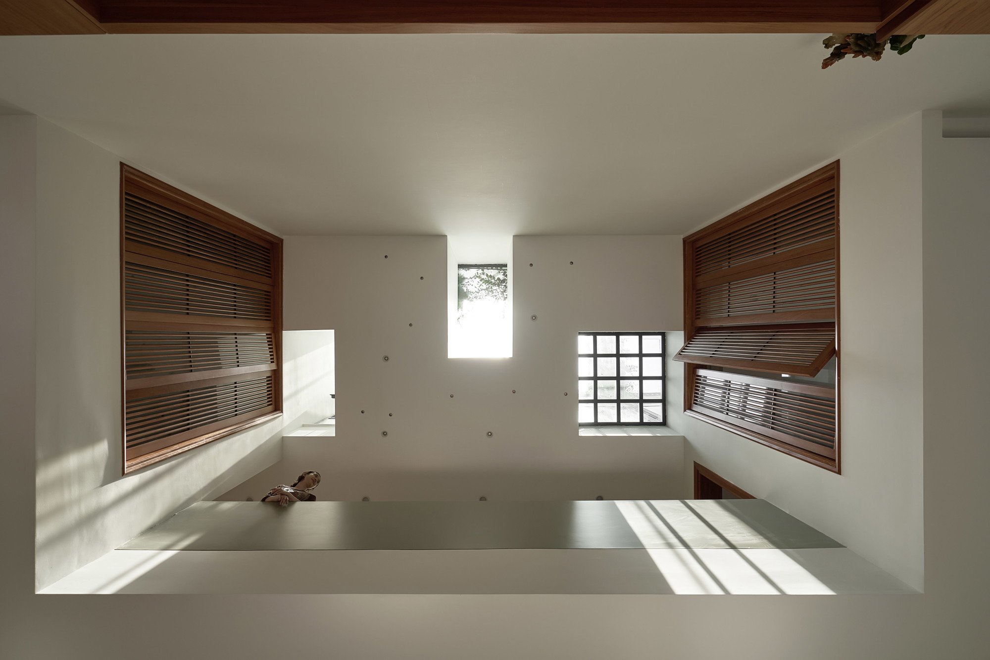 위층 목재 덧창이 둘러싼 PAMA House 중앙 스카이라이트 보이드