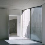 유리문 너머 파티오가 보이는 Trefoil House 실내